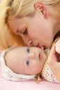 Mother kissing baby daughter