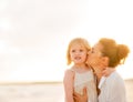 Mother kissing baby girl on beach at the evening Royalty Free Stock Photo