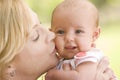 Mother kissing baby outdoors