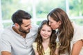 Mother kissing daughter while father watching them Royalty Free Stock Photo