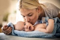 Mother kissing her baby boy sharing tenders at home. Close Royalty Free Stock Photo