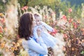 Mother kissing her baby daughter on walk in autumn park Royalty Free Stock Photo