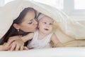 Mother kissing her baby under a blanket Royalty Free Stock Photo