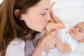 Mother kissing her babys leg on bed Royalty Free Stock Photo