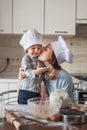 mother kissing her child while they preparing dough Royalty Free Stock Photo