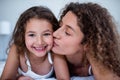 Mother kissing her daughter on the cheek Royalty Free Stock Photo