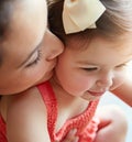 Mother kissing her girl baby on her cheek while playing, bonding and spending time together. Happy, smile and girl Royalty Free Stock Photo