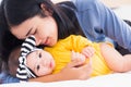 Mother kissing her infant newborn baby in a white bed Royalty Free Stock Photo