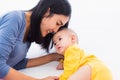 Mother kissing her infant newborn baby in a white bed Royalty Free Stock Photo