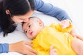 Mother kissing her infant newborn baby in a white bed Royalty Free Stock Photo