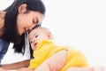 Mother kissing her infant newborn baby in a white bed Royalty Free Stock Photo