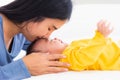 Mother kissing her infant newborn baby in a white bed Royalty Free Stock Photo