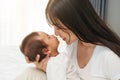 mother kissing her newborn baby on bed Royalty Free Stock Photo