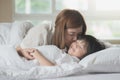 Mother kissing her son on white bed Royalty Free Stock Photo