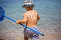 Mother, kissing her toddler child on the beach, sign kiss on his back Royalty Free Stock Photo