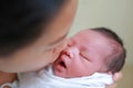 Mother kissing infant baby in her arms in hospital after delivery room Royalty Free Stock Photo