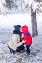 The mother is kissing little boy in winter park Royalty Free Stock Photo