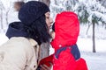 The mother is kissing little boy in winter park Royalty Free Stock Photo