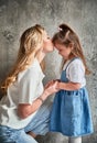 Mother kissing little girl forehead at home. Royalty Free Stock Photo