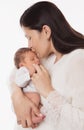 Mother kissing Newborn. Mom Love Baby. Woman holding one Month little Child in Hands over White. Kids Health Care and Parenting Royalty Free Stock Photo