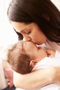 Mother Kissing Sleeping Baby Boy At Home Royalty Free Stock Photo