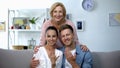 Mother-in-law hugging young couple showing hands with engagement rings at home Royalty Free Stock Photo