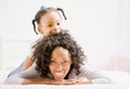 Mother lays on bed with playful daughter Royalty Free Stock Photo