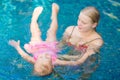 Mother learns daughter to relax in pool water at tropical beach