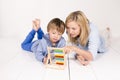 Mother learns to calculate with son on a white floor