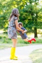 Mother and little adorable child girl in rubber boots having fun Royalty Free Stock Photo