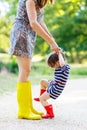 Mother and little adorable child girl in rubber boots having fun Royalty Free Stock Photo