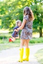 Mother and little adorable child girl in rubber boots having fun Royalty Free Stock Photo