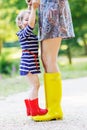 Mother and little adorable child girl in rubber boots having fun Royalty Free Stock Photo