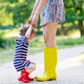 Mother and little adorable child girl in rubber boots having fun Royalty Free Stock Photo