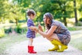 Mother and little adorable child in yellow rubber boots Royalty Free Stock Photo