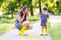 Mother and little adorable child in yellow rubber boots Royalty Free Stock Photo