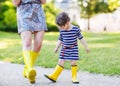 Mother and little adorable child in yellow rubber boots Royalty Free Stock Photo