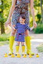 Mother and little adorable child in yellow rubber boots Royalty Free Stock Photo