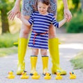 Mother and little adorable child in yellow rubber boots Royalty Free Stock Photo