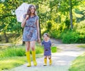 Mother and little adorable child in yellow rubber boots Royalty Free Stock Photo