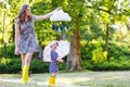 Mother and little adorable child in yellow rubber boots Royalty Free Stock Photo