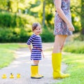 Mother and little adorable child in yellow rubber boots Royalty Free Stock Photo