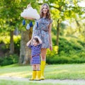 Mother and little adorable child in yellow rubber boots Royalty Free Stock Photo