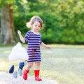 Mother and little adorable child in yellow rubber boots Royalty Free Stock Photo