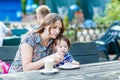 Mother and little adorable kid girl drinking coffee in outdoor c Royalty Free Stock Photo
