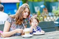 Mother and little adorable kid girl drinking coffee in outdoor c Royalty Free Stock Photo