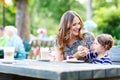 Mother and little adorable kid girl drinking coffee in outdoor c Royalty Free Stock Photo