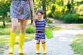 Mother and little adorable toddler child in yellow rubber boots, family look, in summer park. Beautiful woman and cute Royalty Free Stock Photo