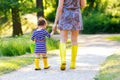 Mother and little adorable toddler child in yellow rubber boots, family look, in summer park. Beautiful woman and cute Royalty Free Stock Photo