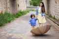 Mother and little baby boy playing with umbrella outdoor in old town Royalty Free Stock Photo